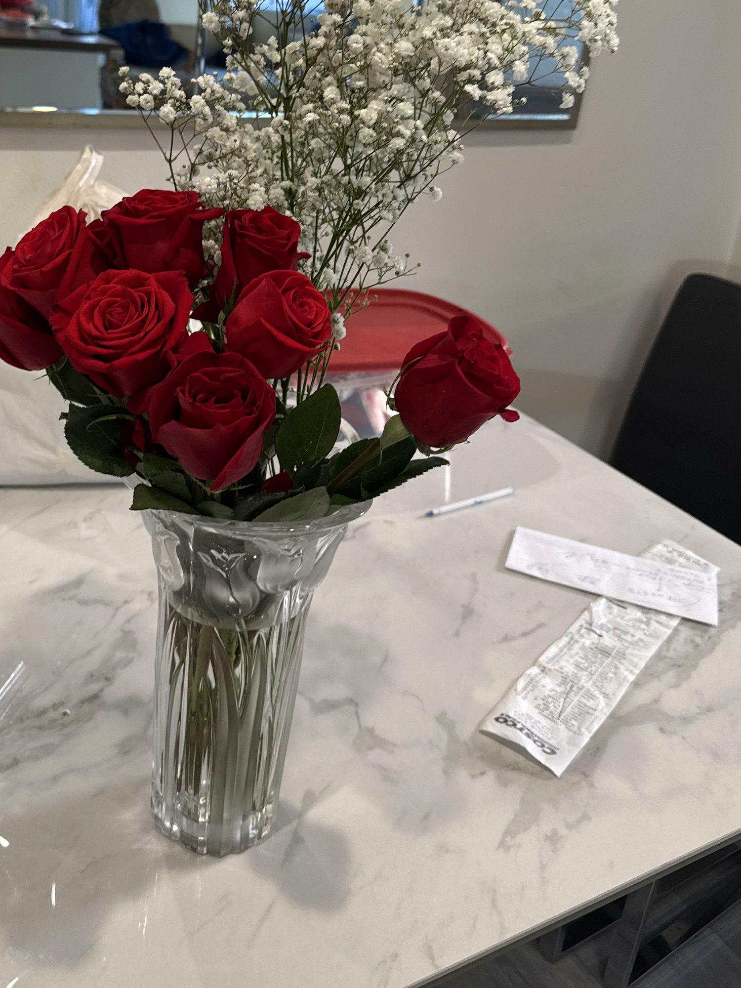 Red roses and baby's breath in a vase on a marble counter